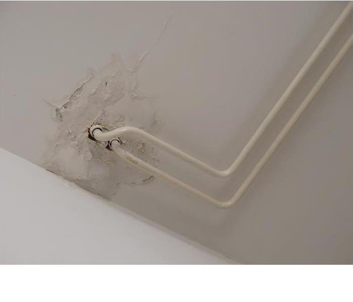 water damage spot on drywall around pipes