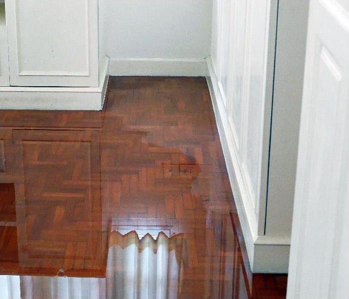 Water spreading on parquet floor in a house
