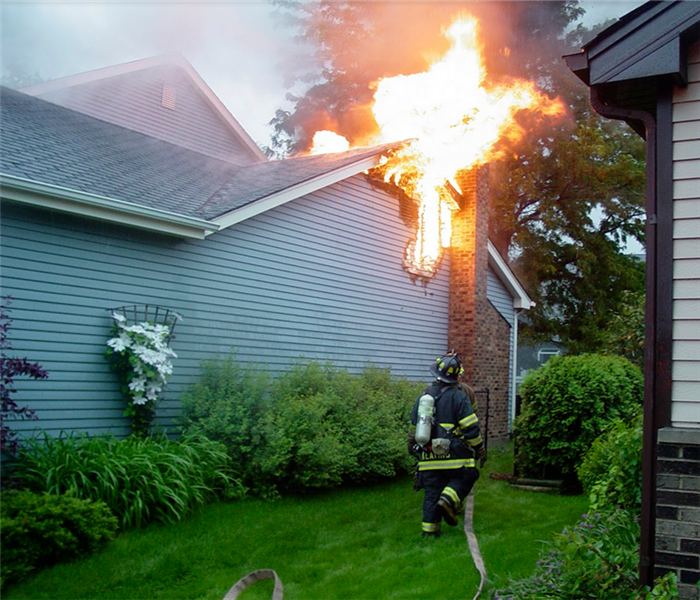 a fireman with a hose trying to put out house fire