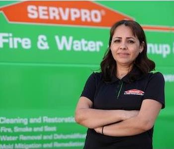Young woman with dark, shoulder length hair and dark eyes wearing a green SERVPRO logo golf shirt by a green SERVPRO truck